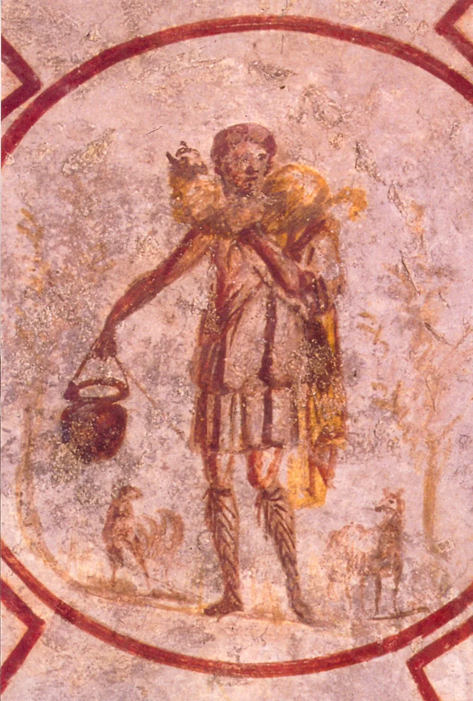 A faded wall painting inside a red circular frame of a young man in a short tunic carrying a sheep across his shoulders and a pail in one hand, standing between two smaller animals.