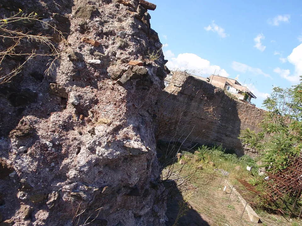 A close-up of the broken edge of the wall, a mass of mortar packed with stone chips, with the rest of the curved wall running off behind.