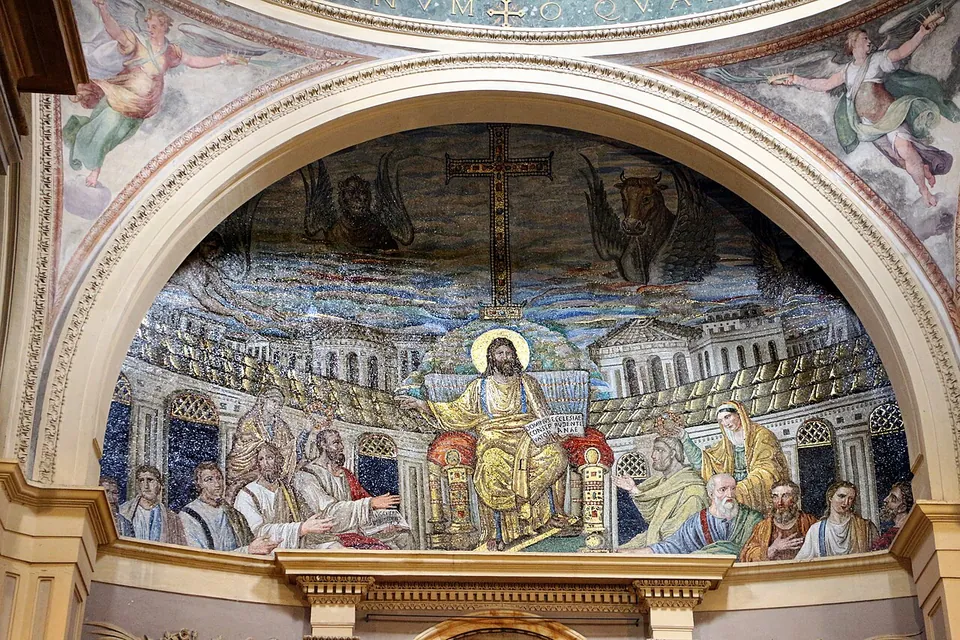 A half-dome mosaic framed by a painted arch. At its centre a haloed, bearded figure in gold robes sits on a jewelled throne, flanked by rows of seated men in pale robes and two standing women; behind them runs a curved portico and a skyline of buildings, and above, against a blue and red sky, a tall gold cross with winged creatures on either side.