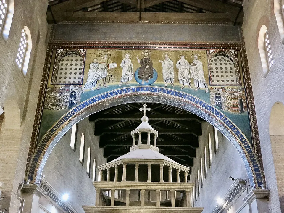 A great arch inside the church, its face covered in gold-ground mosaic with Christ seated on a blue globe at the centre and three robed figures on each side, a lettered band running round the curve of the arch, two latticed windows and small walled cities in the corners, and a white canopy over the altar seen through the opening.