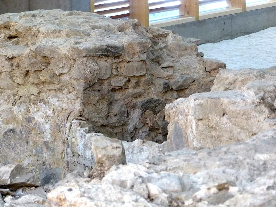 Close view of a small rectangular basin sunk among rough, pale stone walls, its sides lined with a smooth grey render.