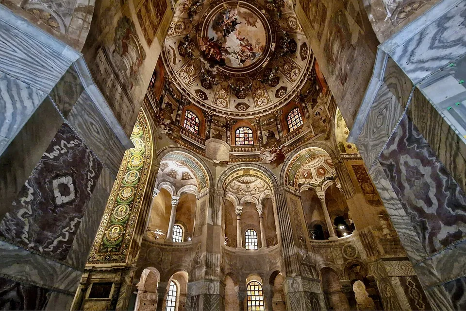 Looking straight up inside the church. A painted dome with figures among clouds crowns a ring of arched openings on two storeys of columns; a mosaic-covered arch appears at the left, and marble-faced piers frame the view.