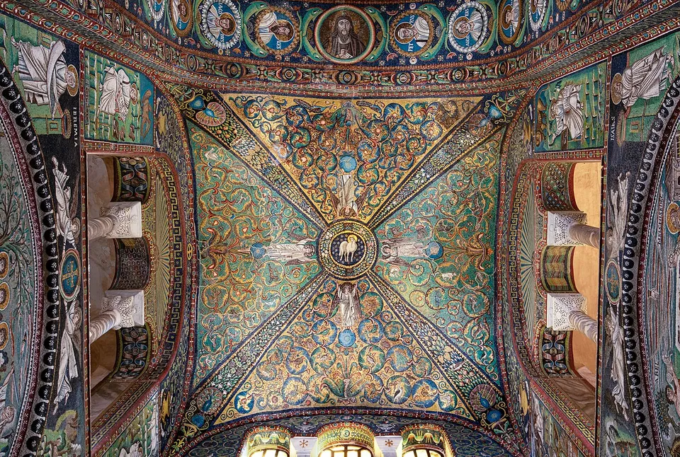 Looking up into a cross-vault covered in mosaic, green and gold foliage spreading over its four segments from a small central medallion, framed by a band of portrait roundels, with columns and arched windows at the edges.