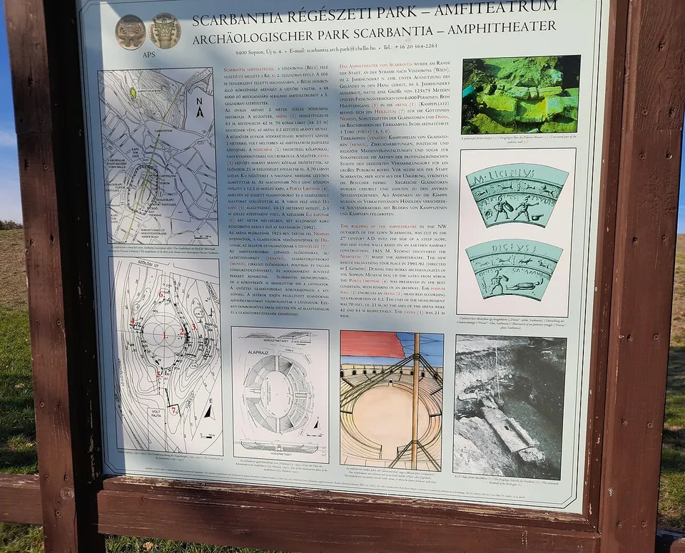 An information board on a wooden frame headed "Scarbantia Régészeti Park – Amfiteátrum" and "Archäologischer Park Scarbantia – Amphitheater", with text in Hungarian and German, plans of the amphitheatre and a drawing of its reconstruction.