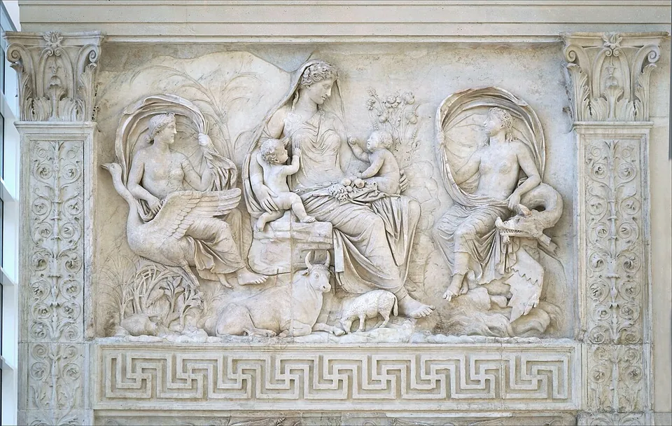 A marble relief of a seated woman holding two infants on her lap, flanked by two half-draped female figures, one seated on a large bird and one on a sea creature, with a cow and a sheep lying at her feet and a meander border below.